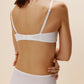 A woman wears a white bra and brief from back.