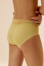 A woman wears a yellow brief.