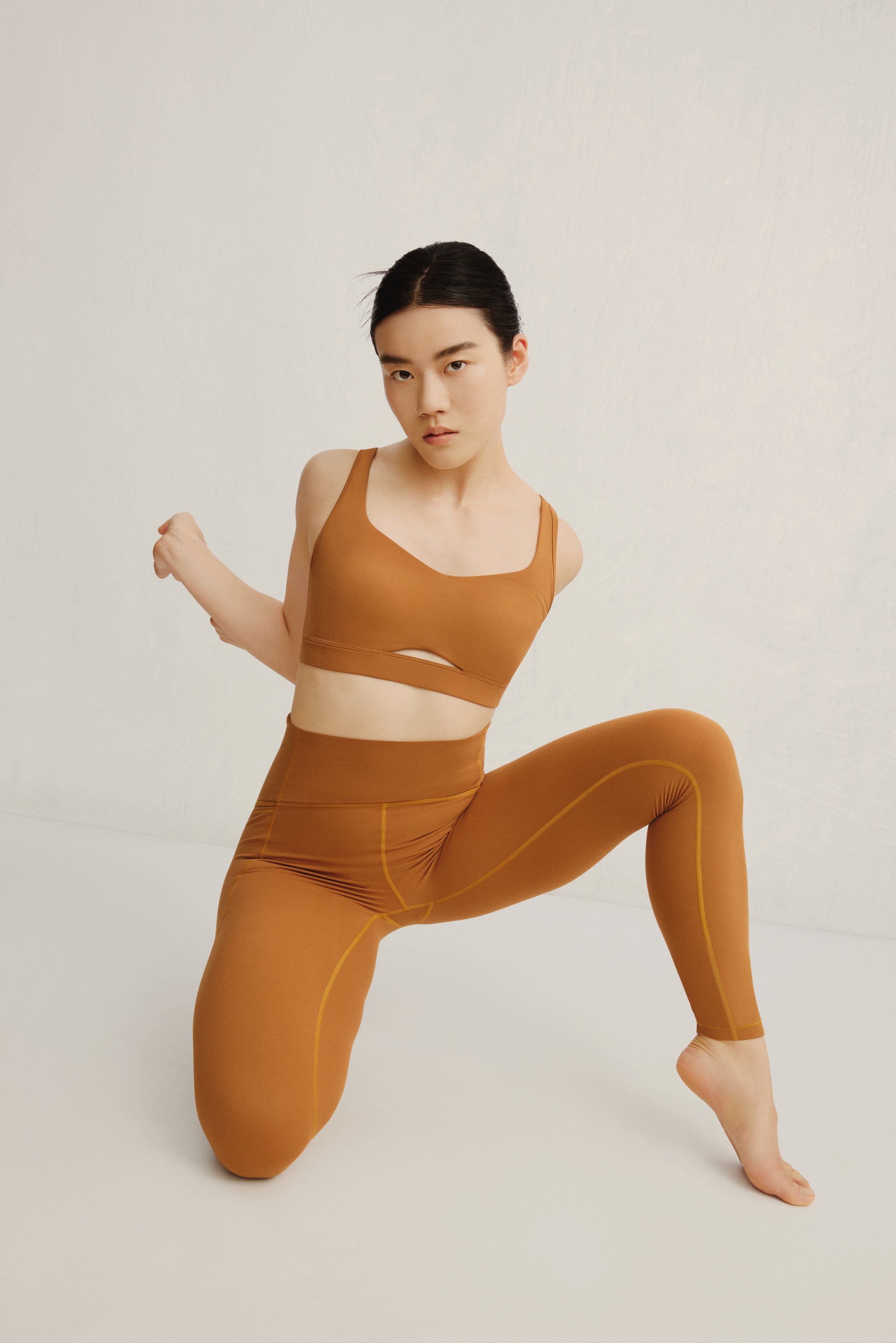 woman in mustard sports bra and leggings