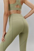 Back of woman wearing light green leggings and matching sports bra
