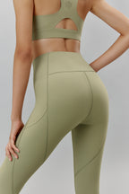 Back of woman wearing light green leggings and matching sports bra