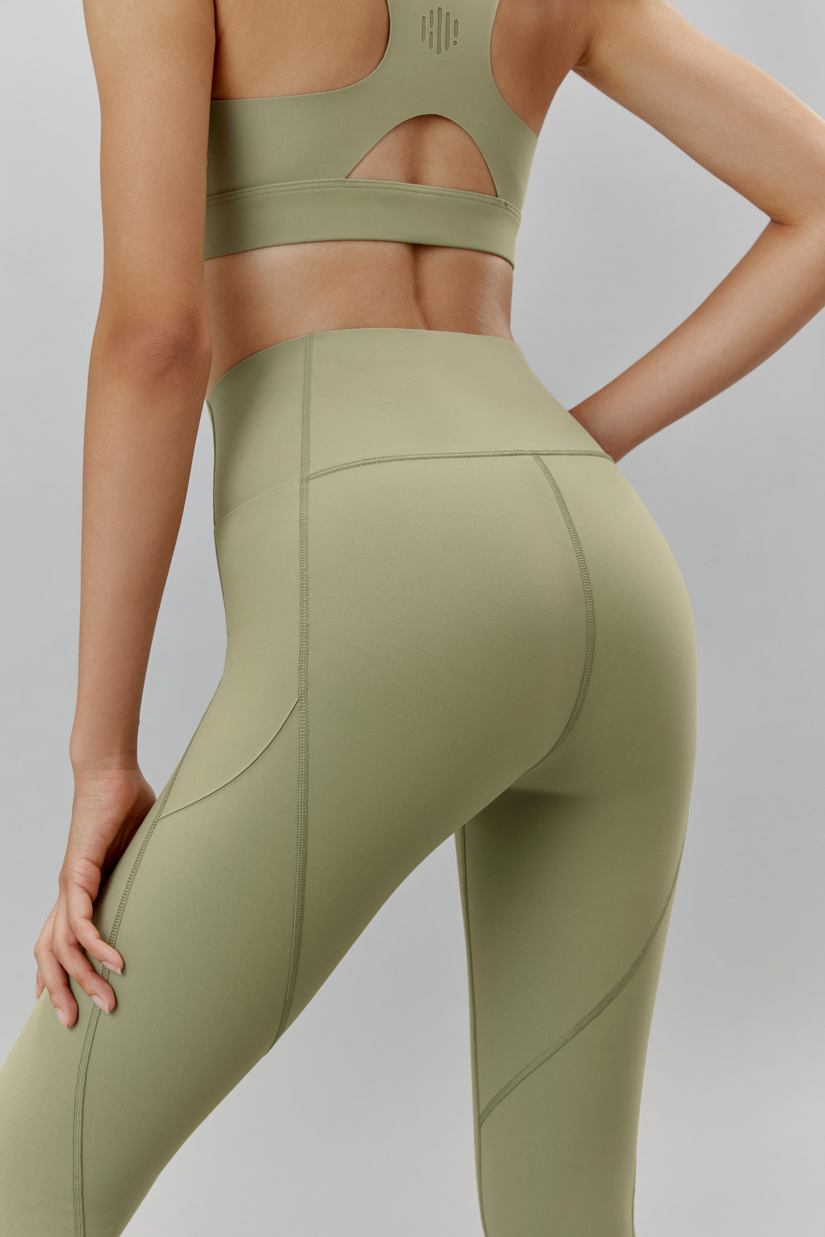 Back of woman wearing light green leggings and matching sports bra