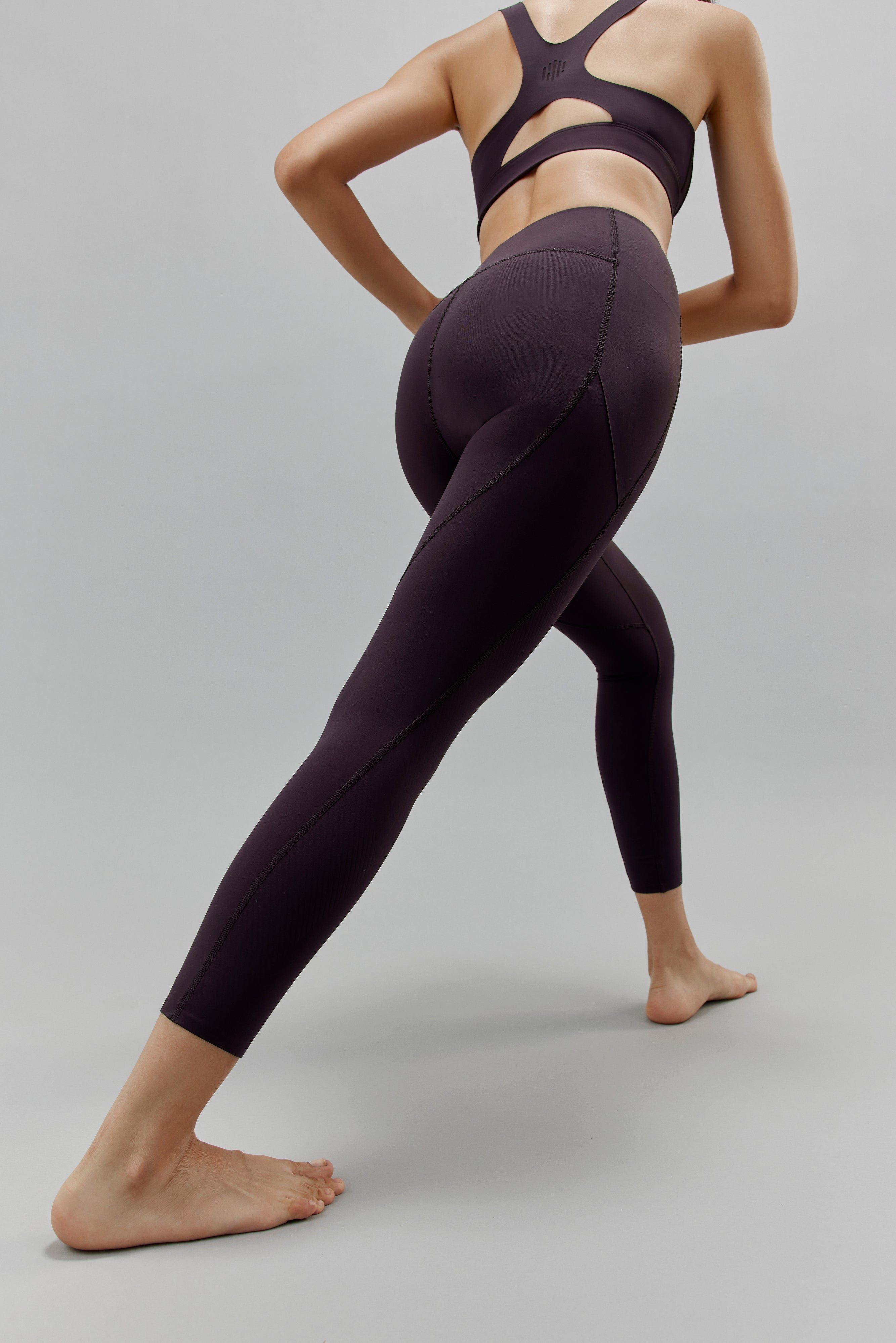 Back of woman wearing black leggings and matching sports bra