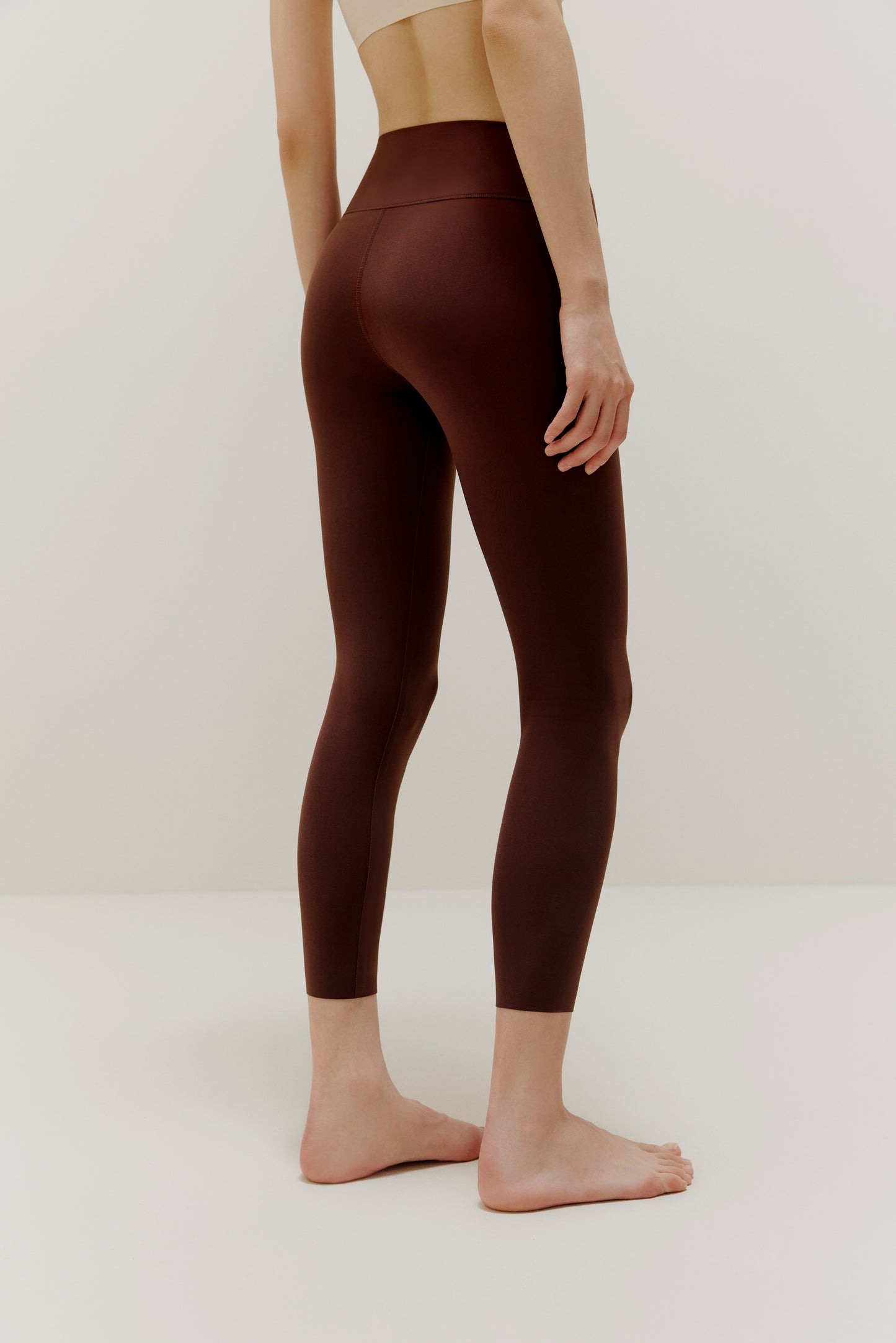 Back side view of woman wearing brown leggings