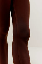 Close up of knee of woman wearing brown leggings
