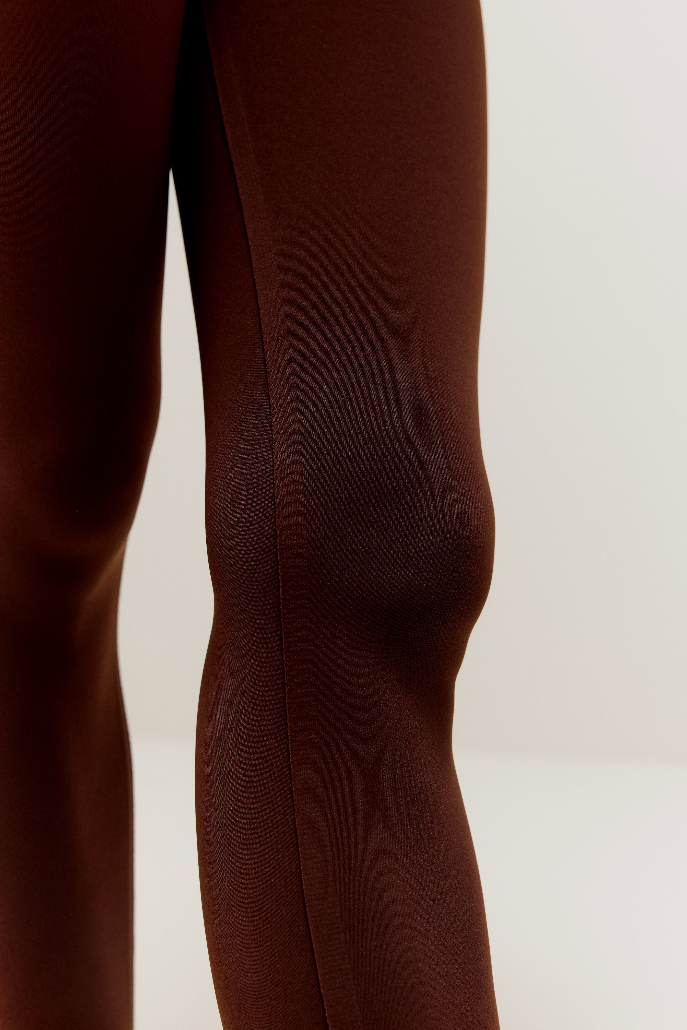 Close up of knee of woman wearing brown leggings