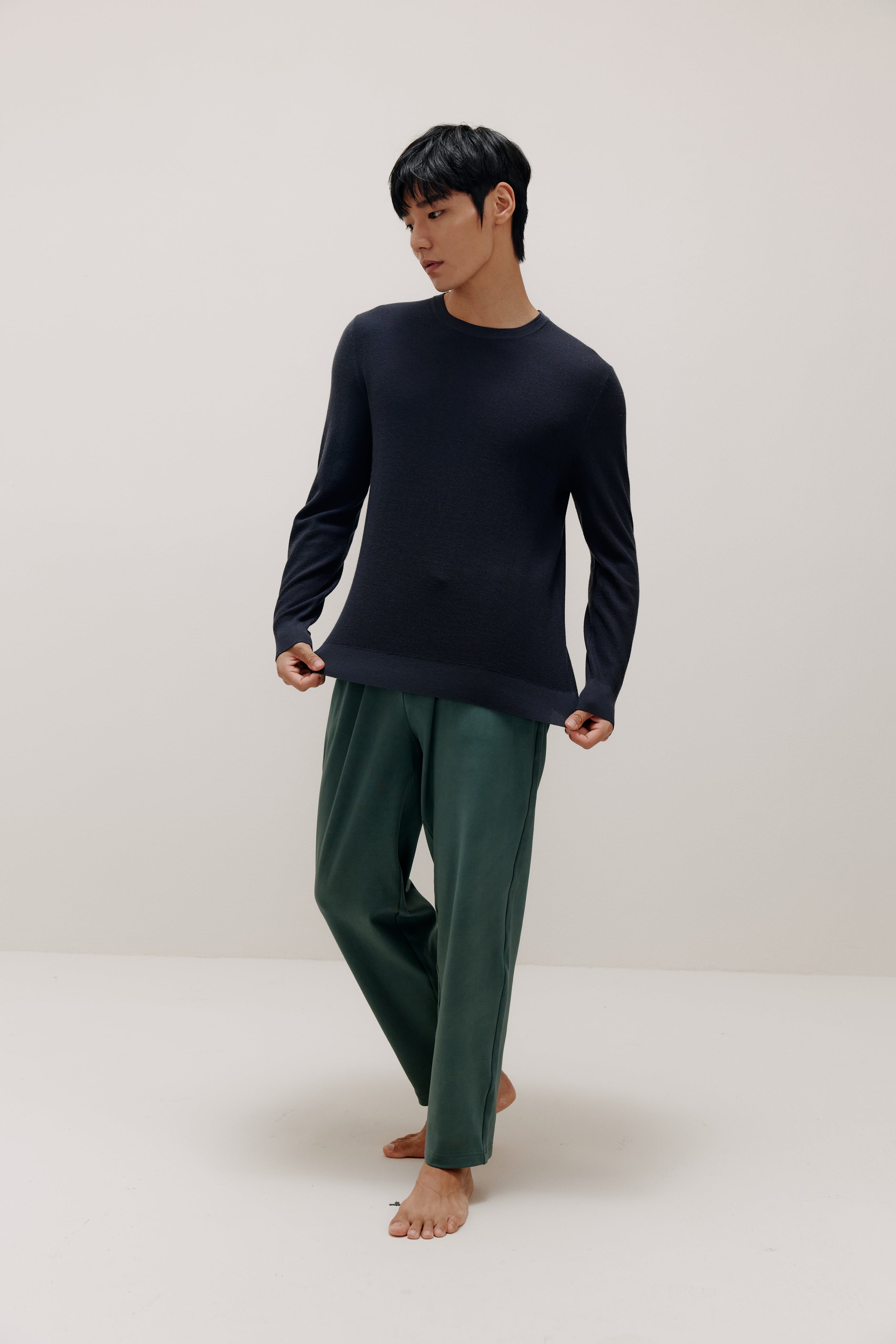 man in navy sweater and green pants