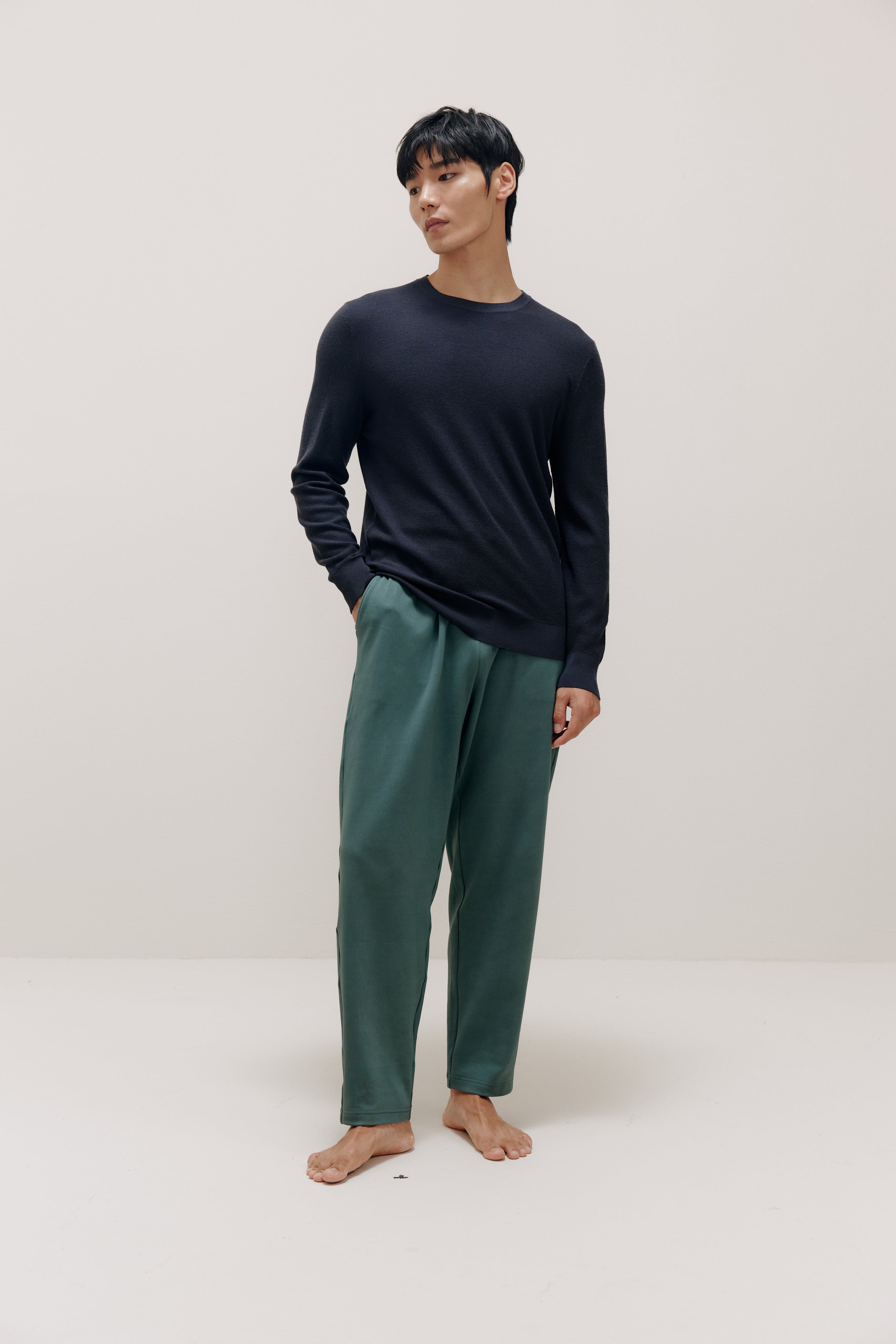 man in navy sweater and green pants