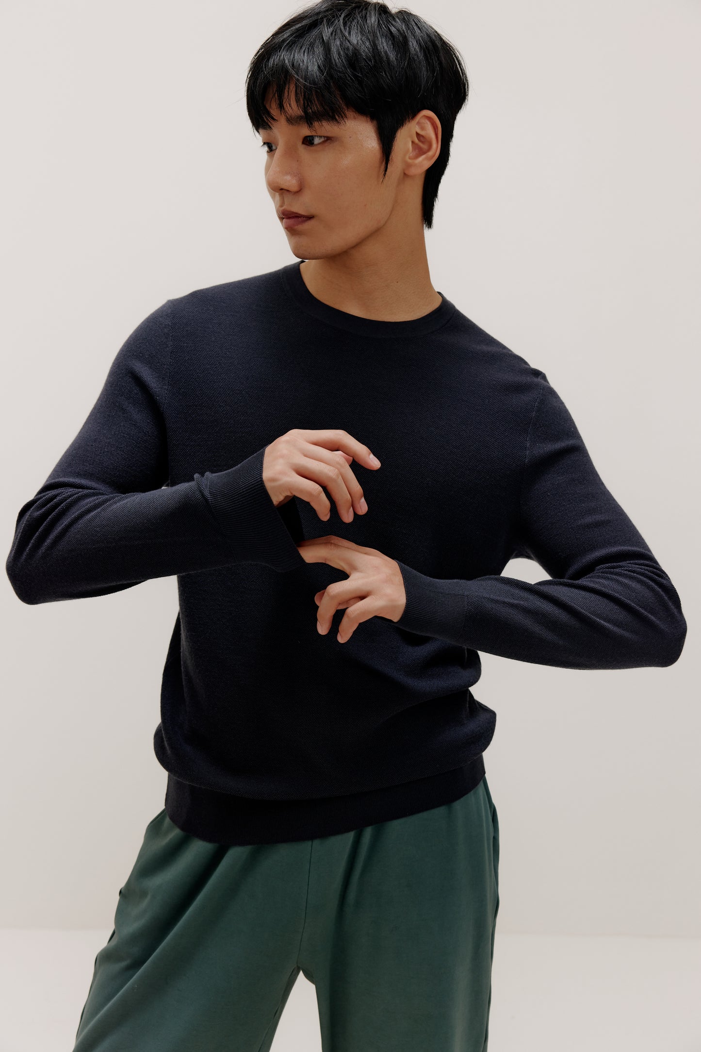 man in navy sweater and green pants