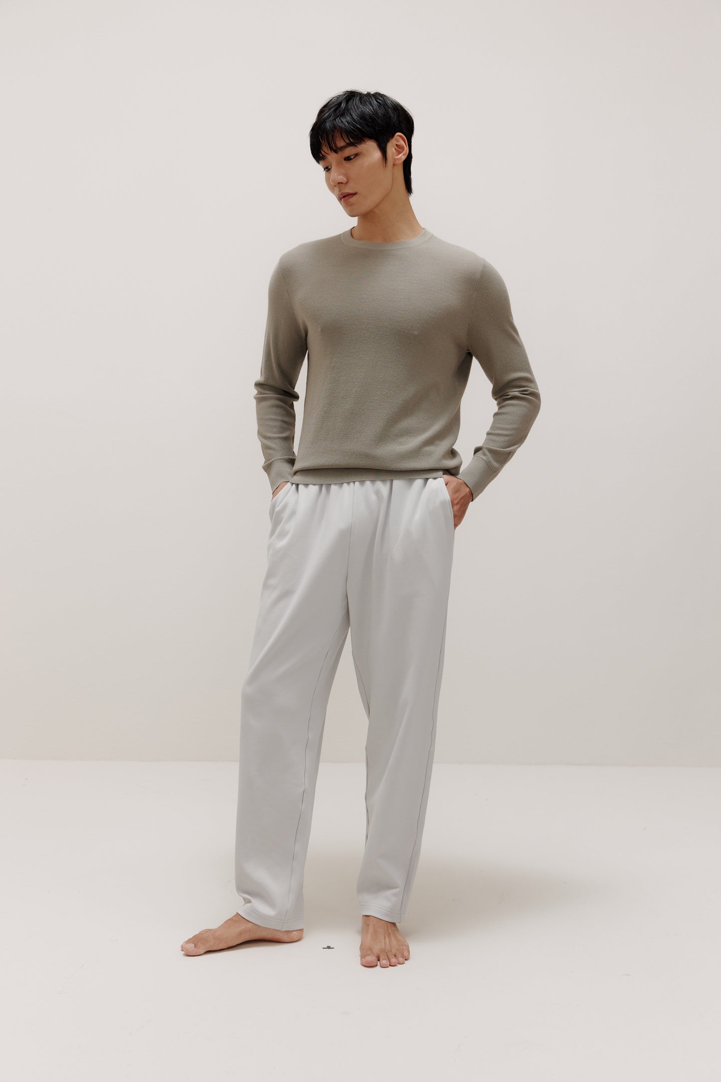 man in khaki sweater and grey pants