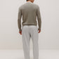back of man in khaki sweater and grey pants