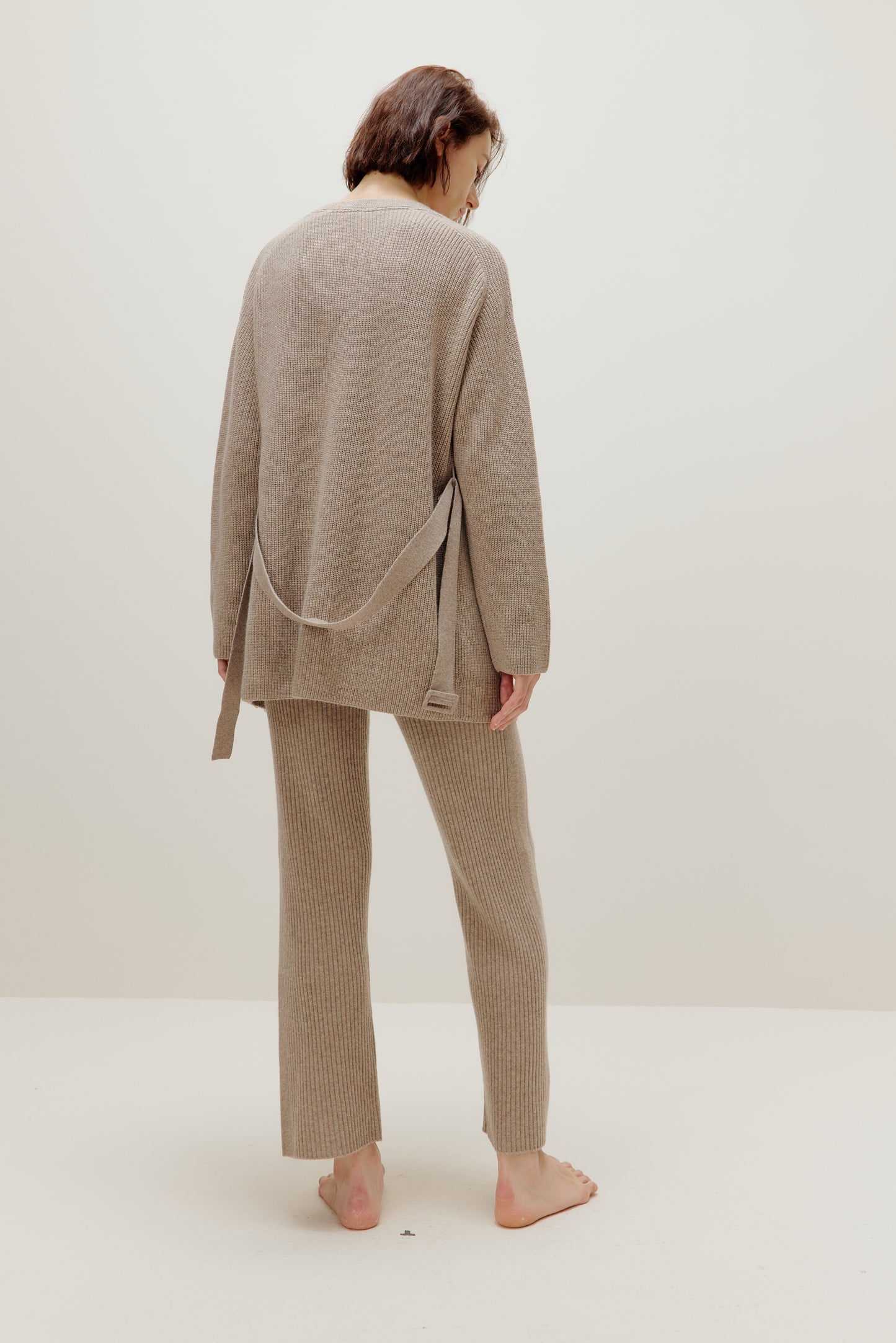 back of woman in knitted brown cardigan and pants