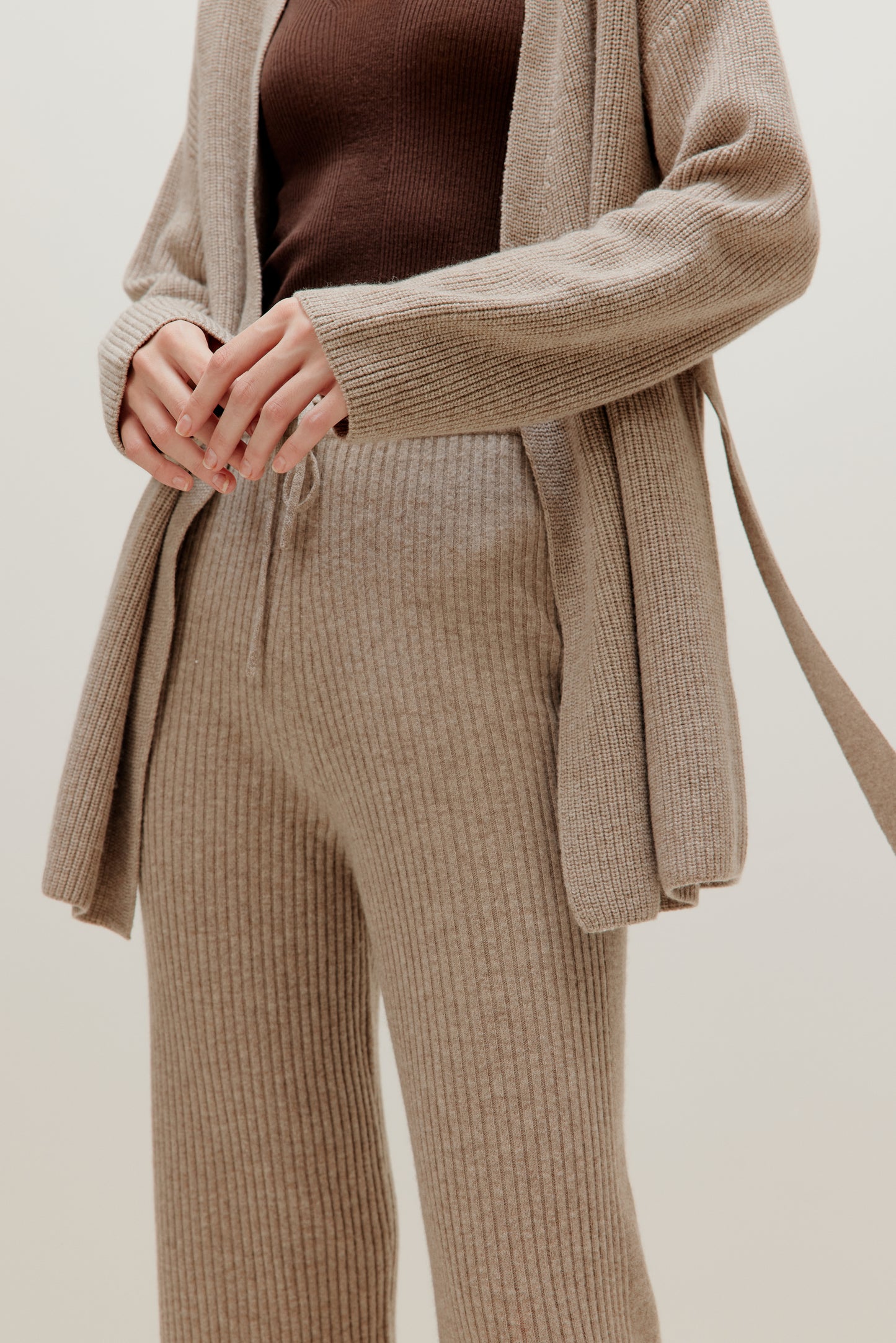 close up of woman in knitted brown cardigan and pants