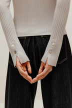 the gray silky wool zip-up cardigan and black pants from back