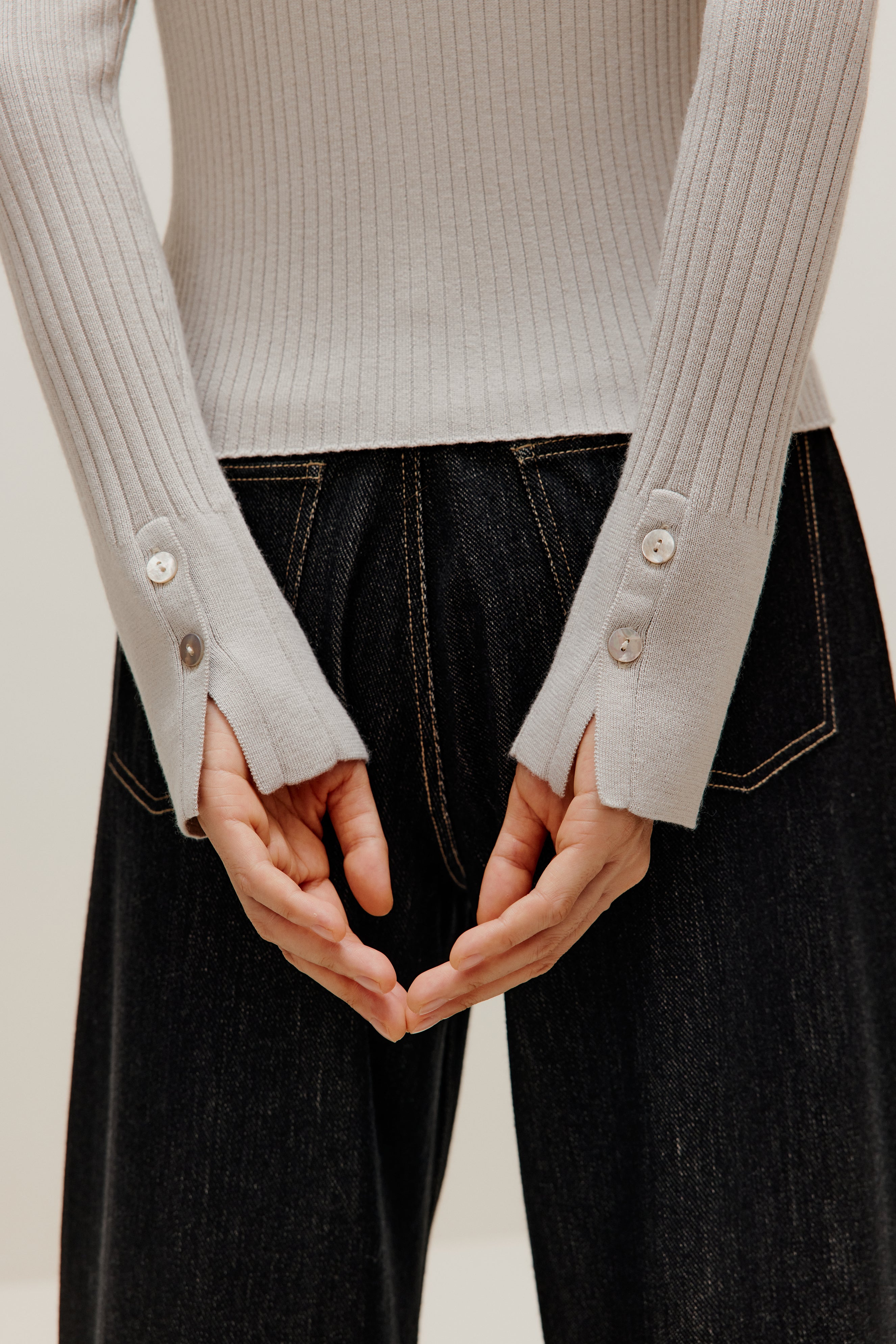 the gray silky wool zip-up cardigan and black pants from back