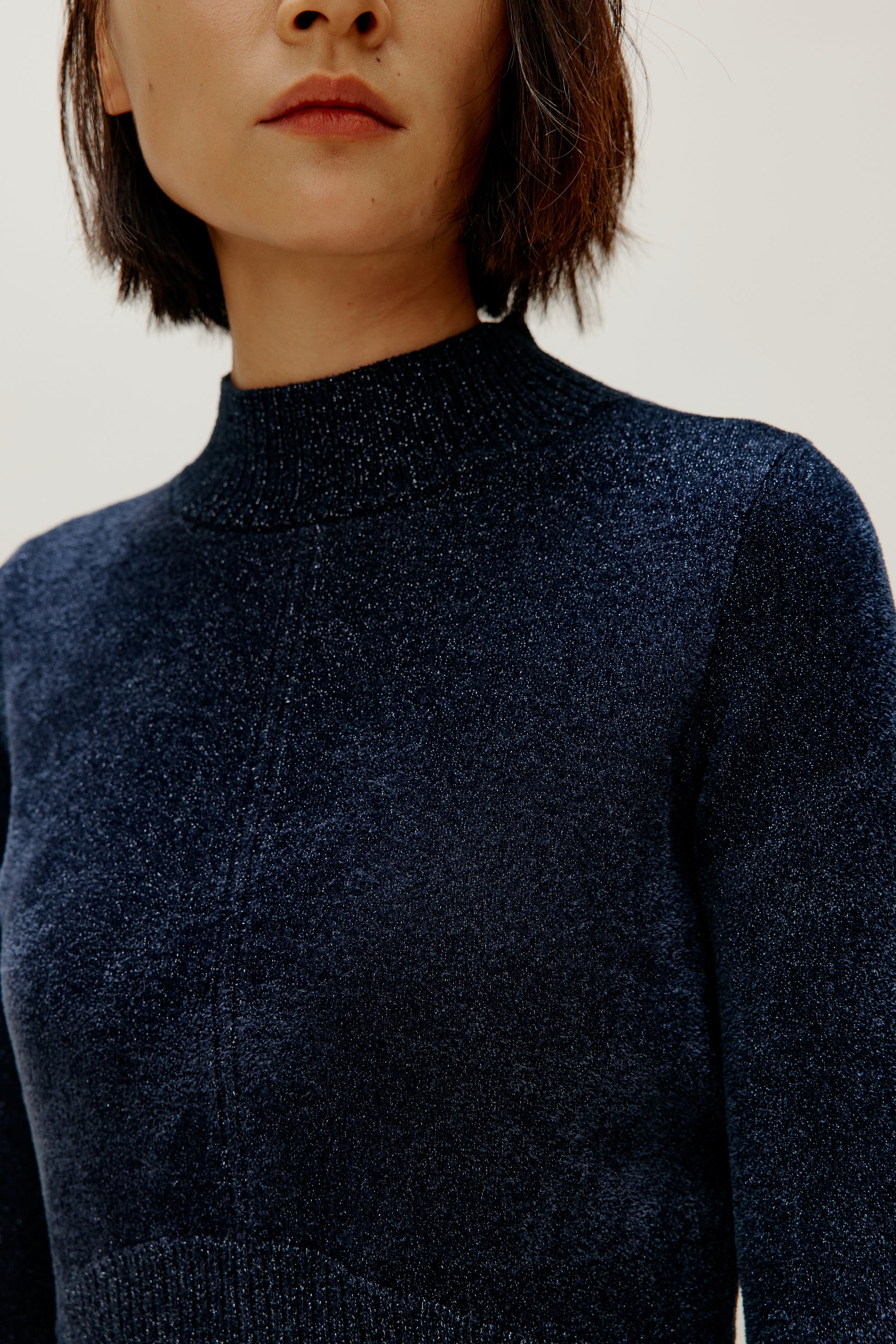 woman wearing blue shimmer mock neck sweater close up shot
