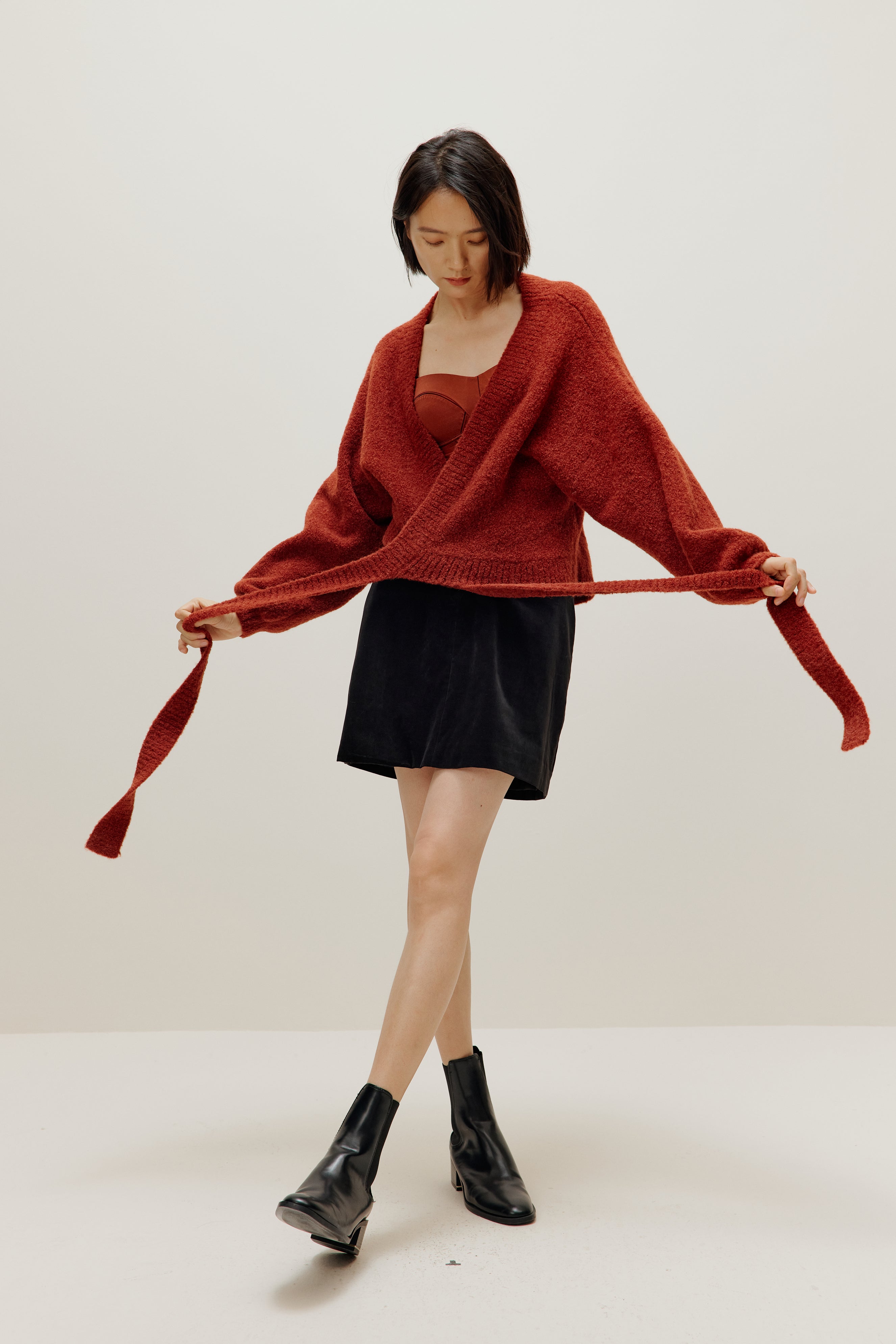 woman wearing a red wrap Cardigan and black skirt