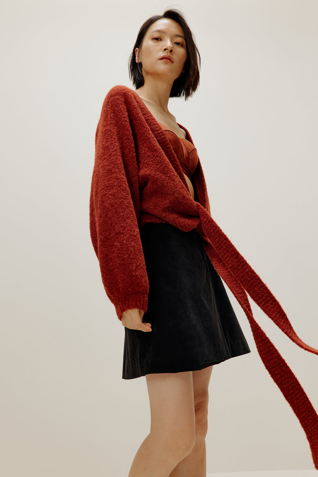 woman wearing a red wrap Cardigan and black skirt