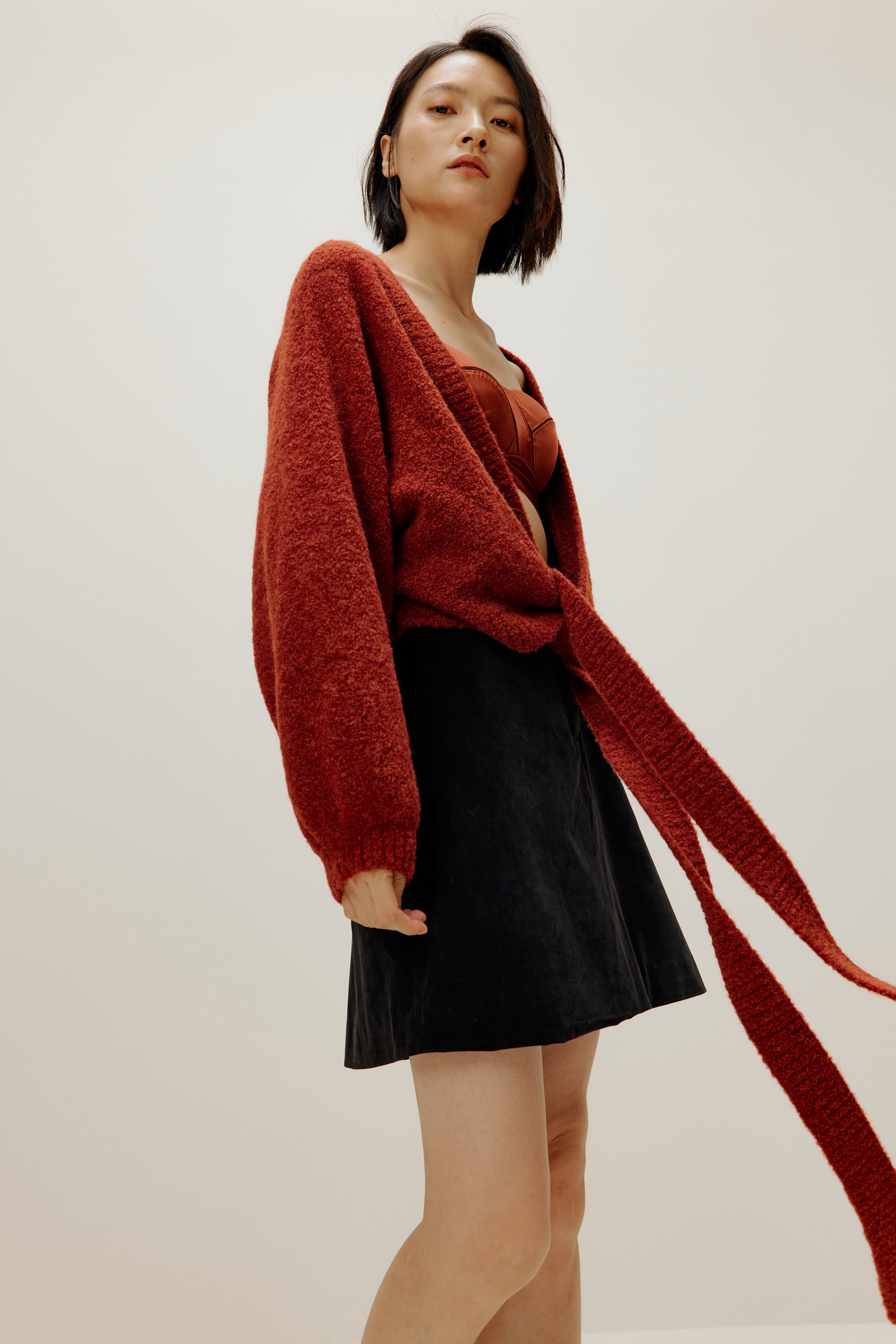 woman wearing a red wrap Cardigan and black skirt