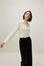 woman in white satin shirt and black bottoms