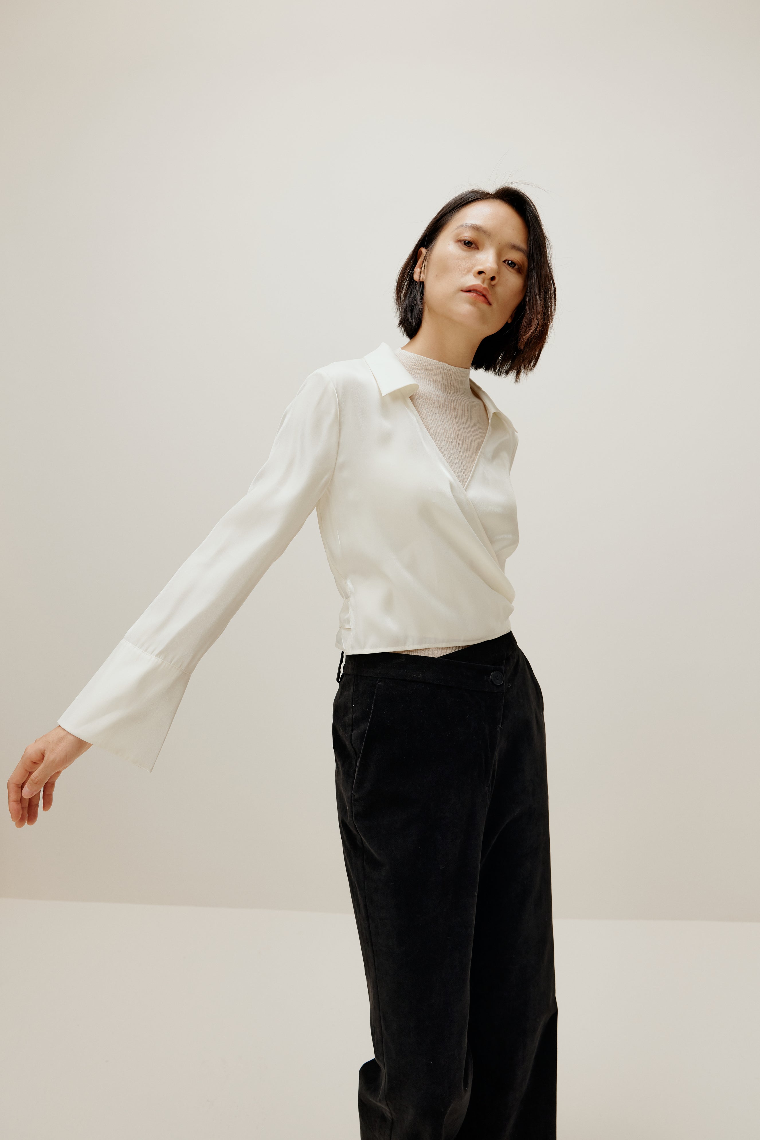 woman in white satin shirt and black bottoms