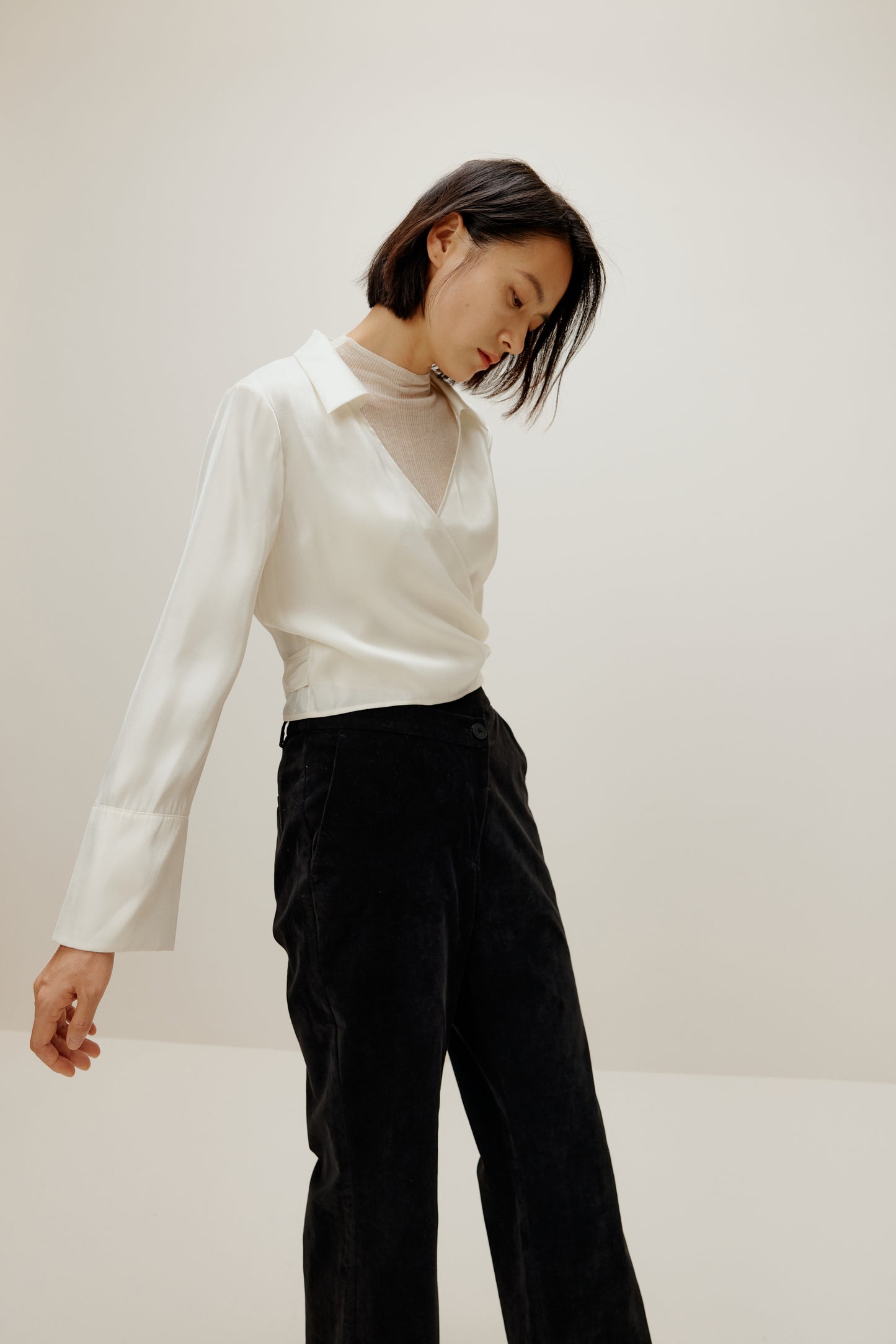 woman in white satin shirt and black bottoms