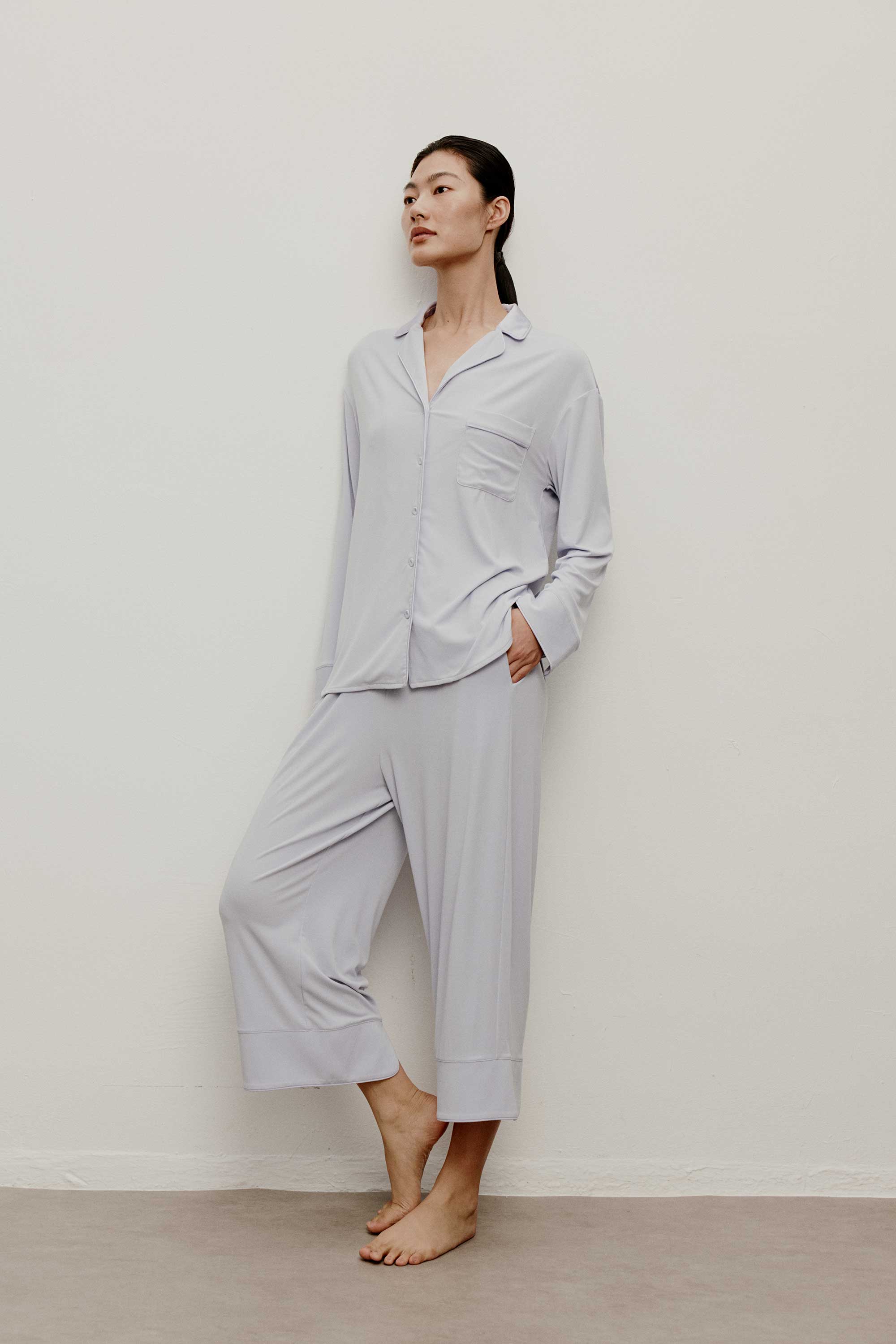 a woman wearing a light blue pajama set standing