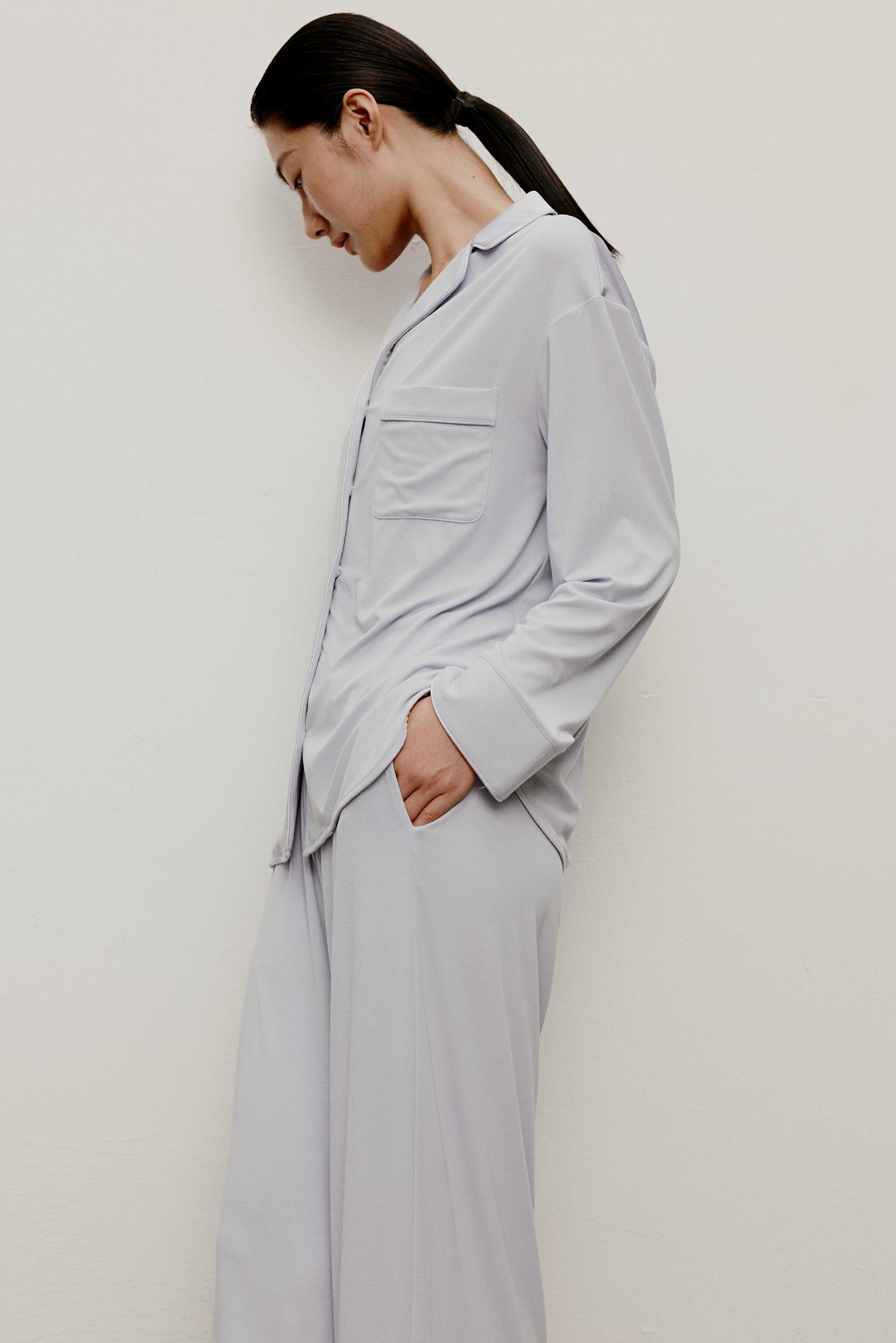 side of a woman wearing a light blue pajama set standing