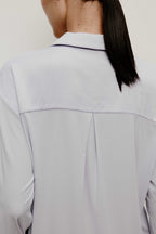 back of a woman wearing a light blue pajama top