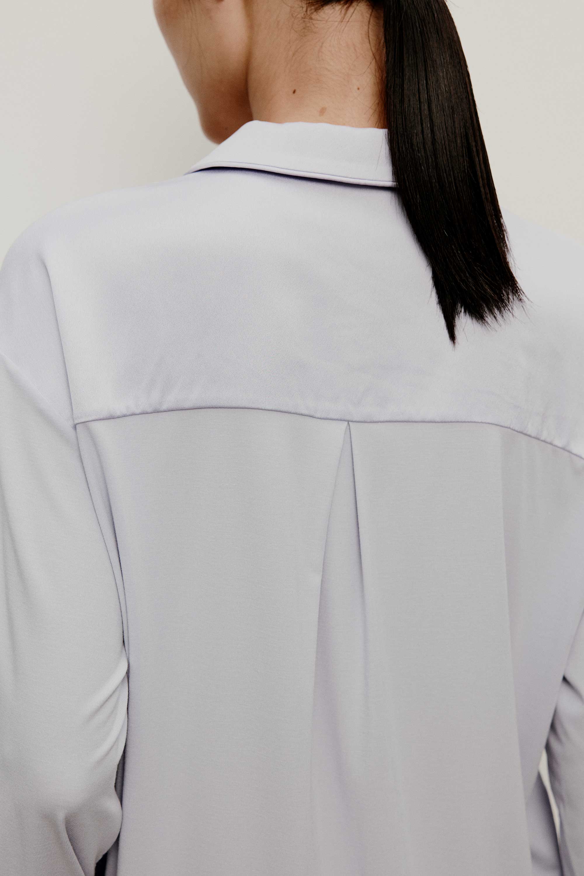 back of a woman wearing a light blue pajama top