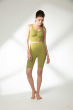 woman in green sports bra and green biker shorts