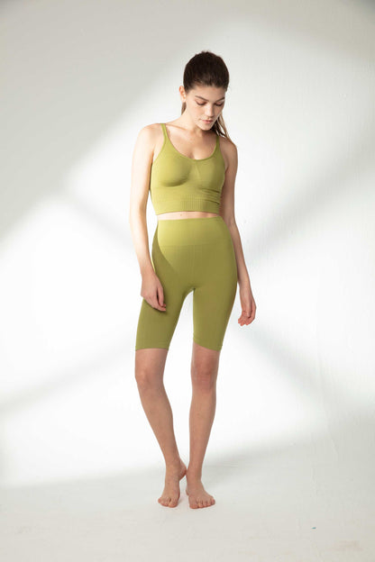 woman in green sports bra and green biker shorts