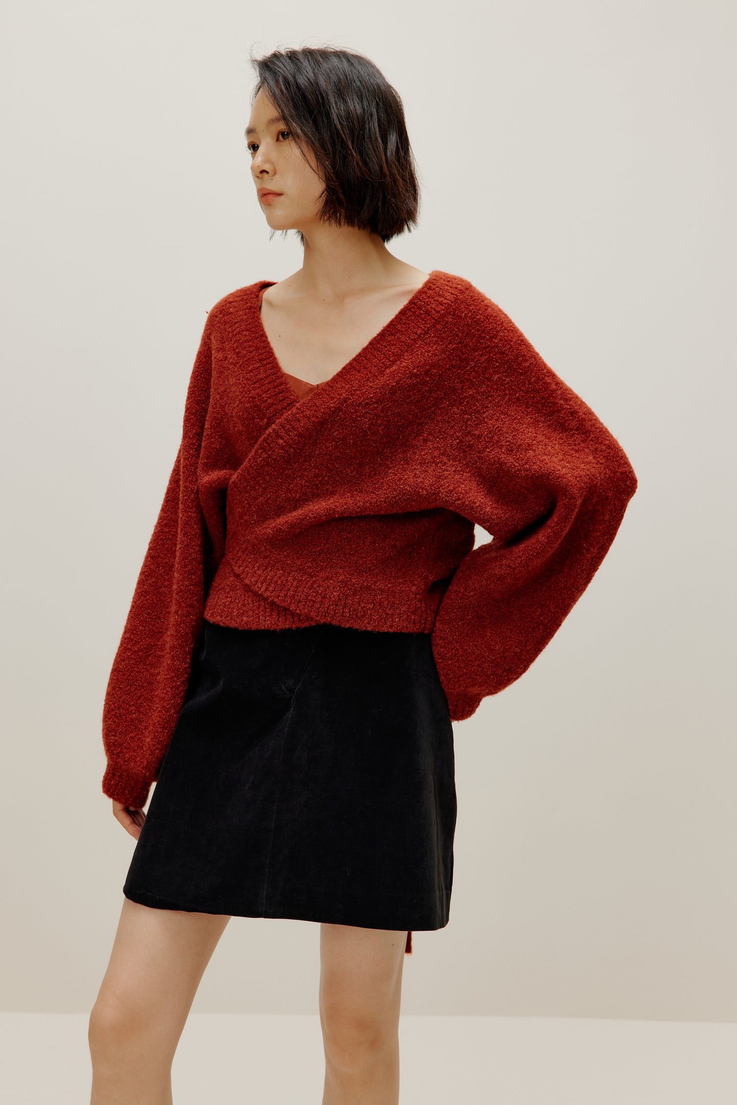 woman wearing a red wrap Cardigan and black skirt