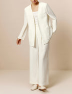 Front view of model wearing ivory blazer with matching ivory tank and pants. 