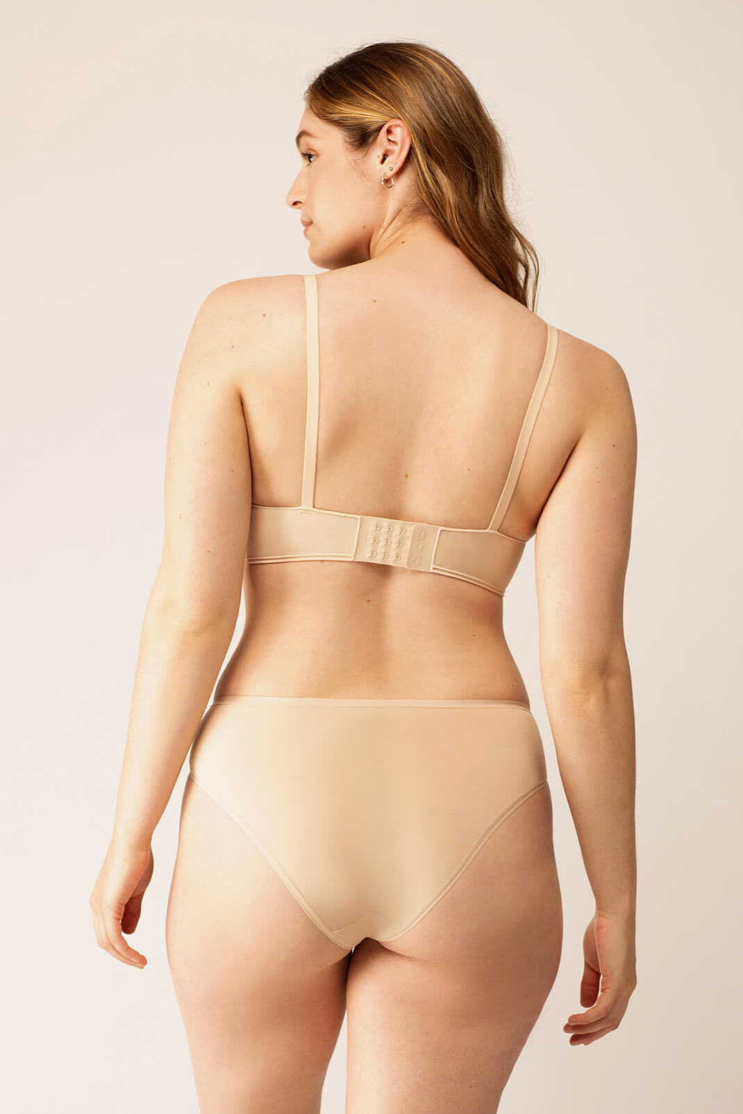Back view of woman wearing beige bra with matching briefs