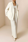 Front side view of woman wearing ivory blazer, ivory tank, and ivory pants.