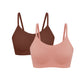 Flat lay image of coral and burgundy spaghetti strap bras