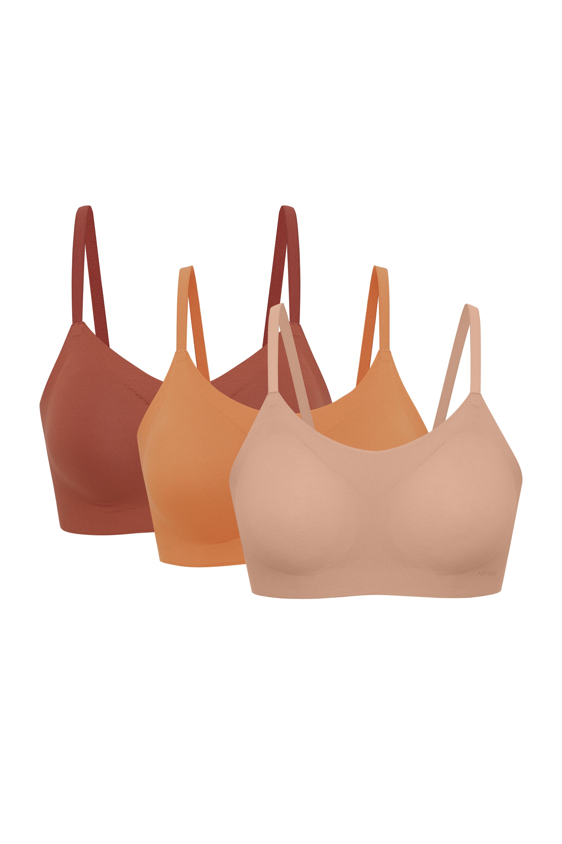 Flat lay image of tan, light orange, and dark orange spaghetti strap bras