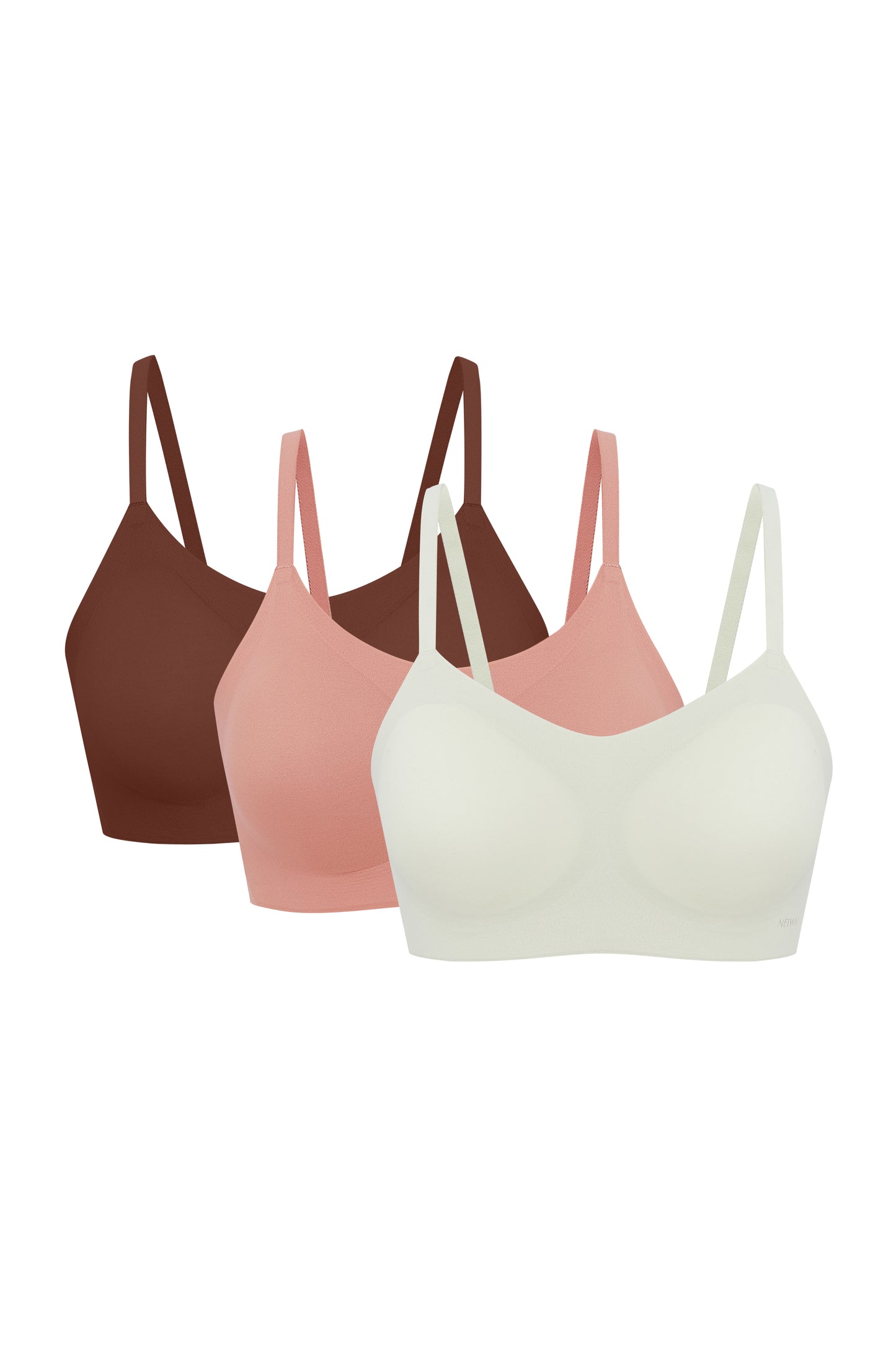 Flat lay image of off-white, coral, and brown spaghetti strap bras