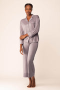 Woman wearing light purple button up pajama shirt with pocket and matching pajama bottom