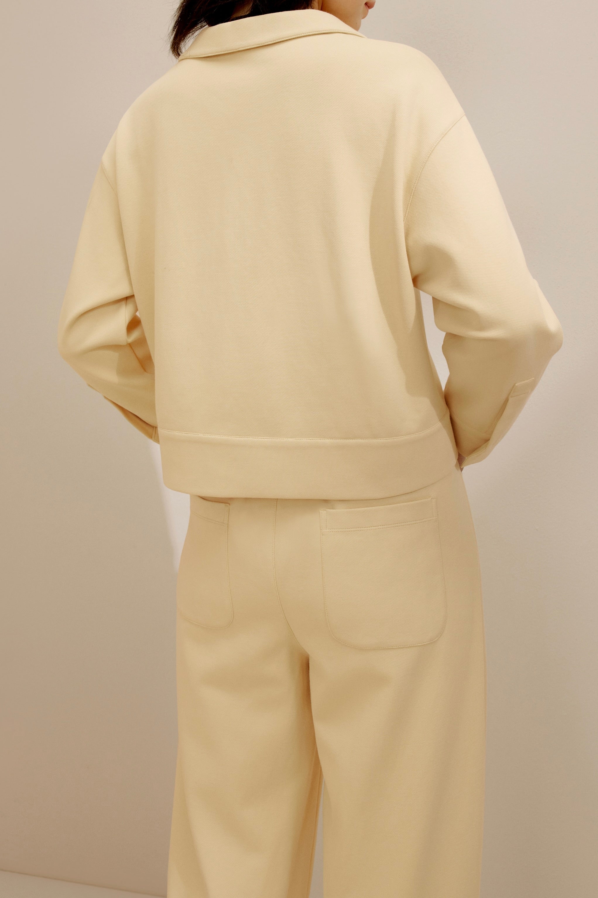 back of the women in the yellow polo shirt and pants