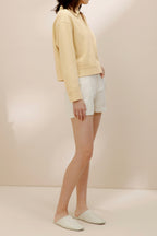 side of women in the yellow polo shirt and white shorts