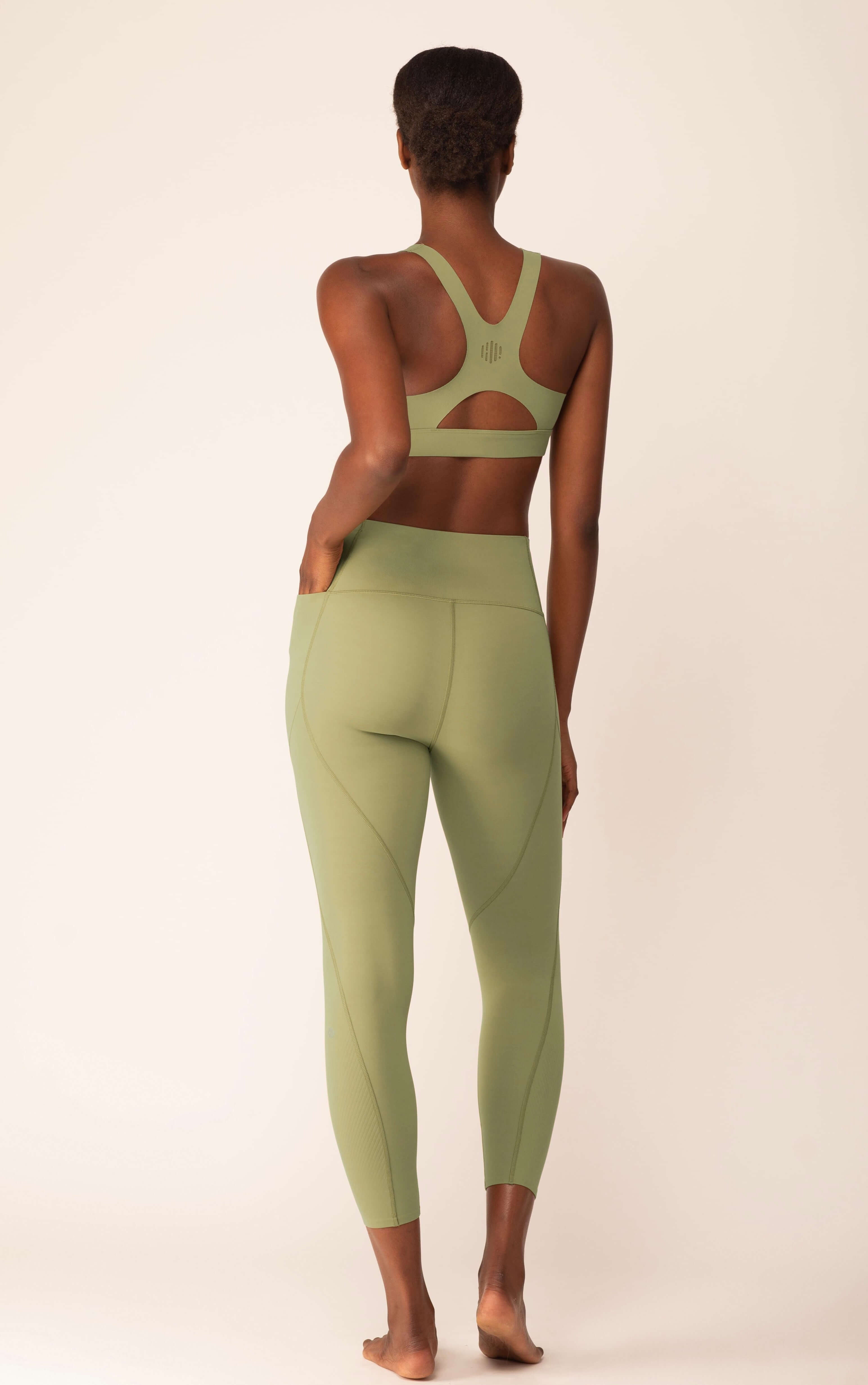Back of woman wearing light green leggings and matching sports bra