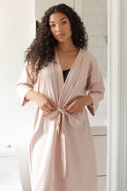 woman in light pink long pajama robe