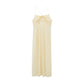 Flat lay image of back of cream colored dress with thin straps and cross back design