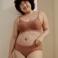 Woman wearing cinnamon color spaghetti strap bra and midwaist seamless brief.