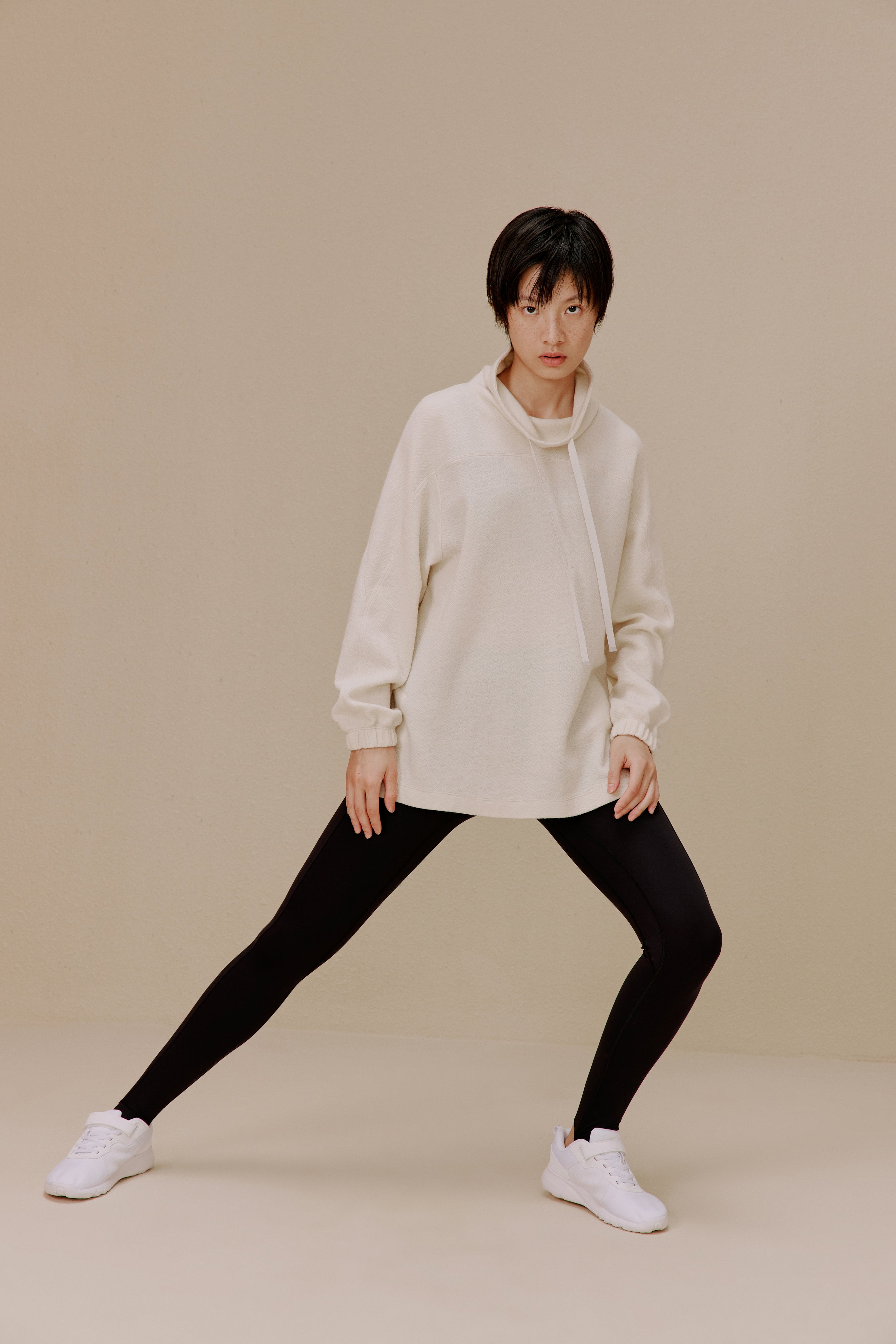 Woman in white pullover and black leggings
