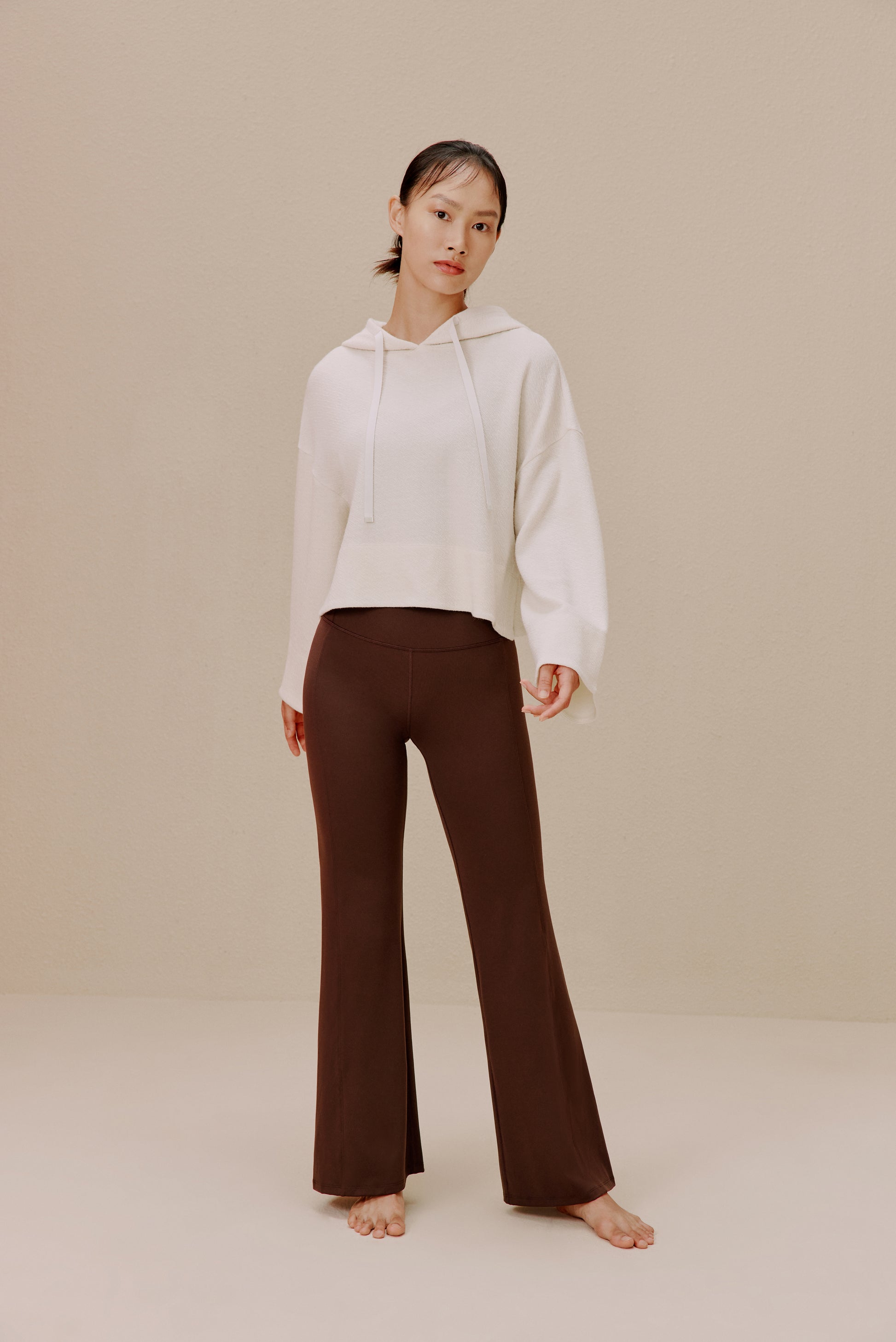 Woman wearing white sweatshirt and brown wide-leg pants