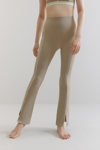 A woman wears grey flare leggings with two white lines on the sides