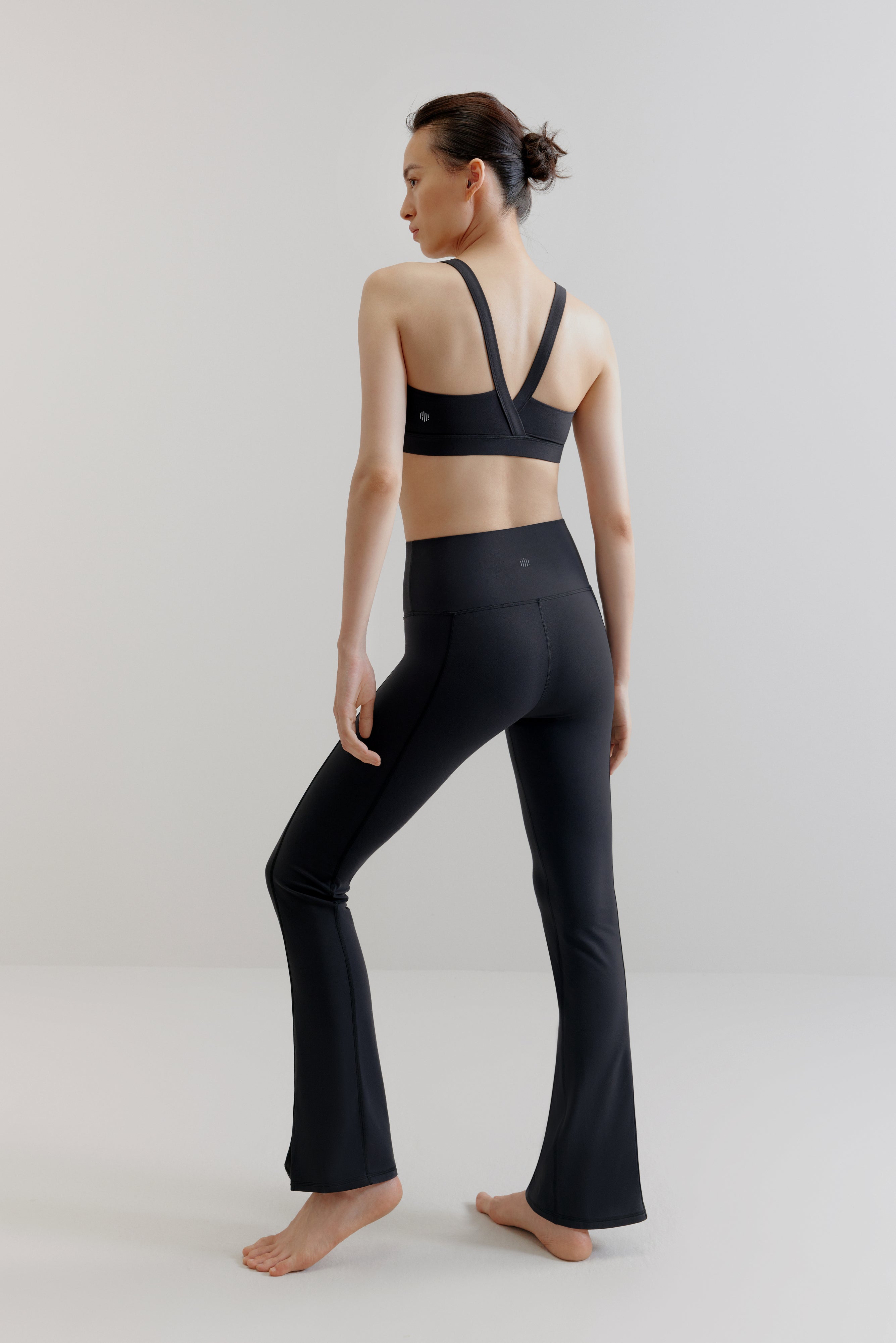 back of woman in black sports bra and leggings